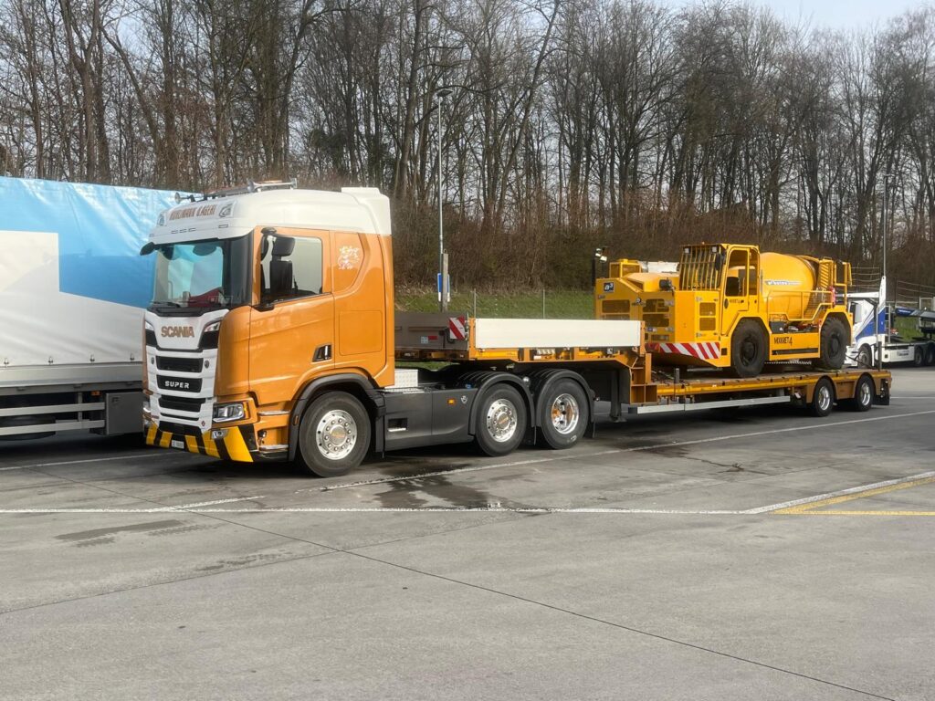 Tiefbett-Spezialtransport mit Baumaschine auf Tieflader der A. Hürlimann Transport AG