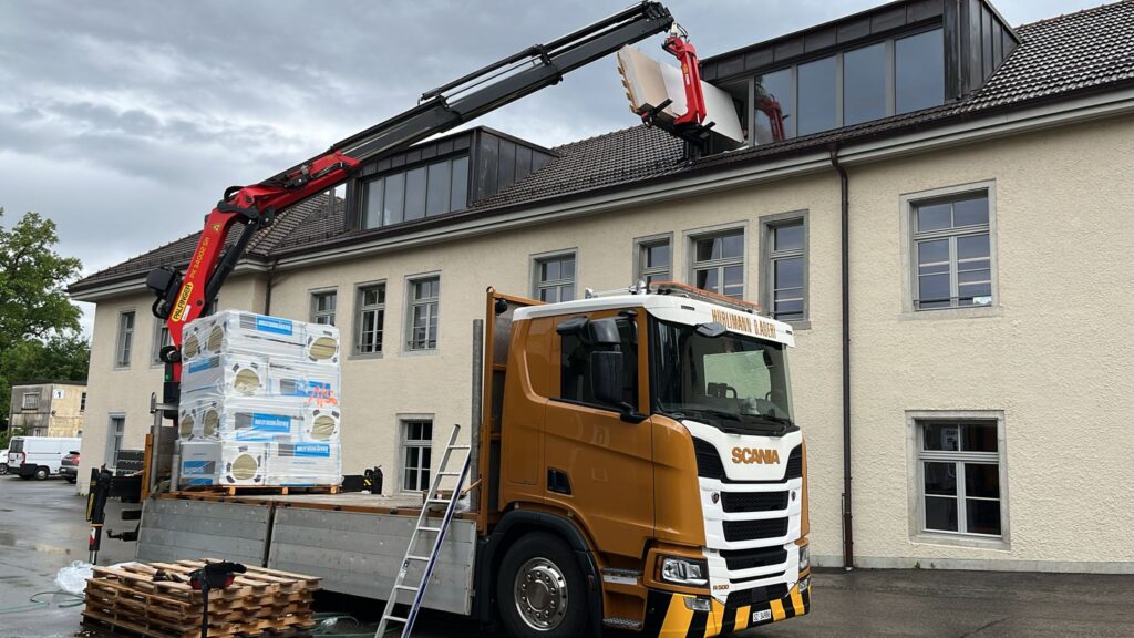 Kranarbeiten mit Wendegabel und Lastwagenkran bei Montagearbeiten an einem Gebäude in der Zentralschweiz